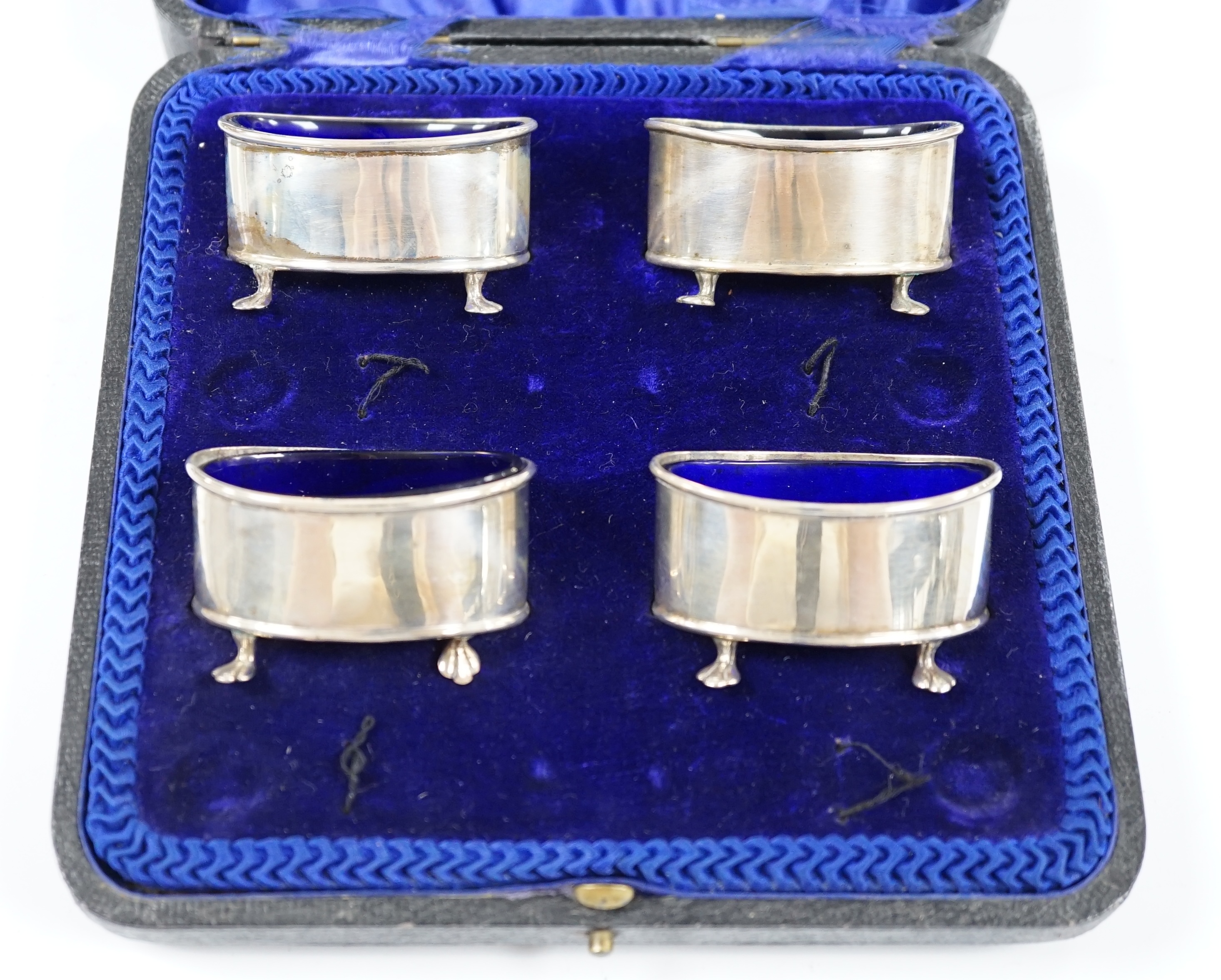 A cased set of four George V silver oval salts, with blue glass liners, Cooper Brothers & Sons, Sheffield, 1912, length 57mm. Condition - fair